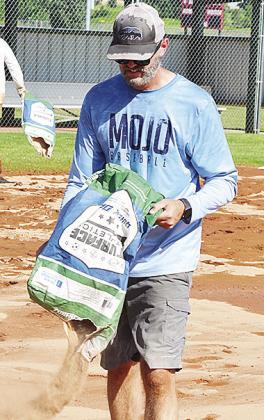 Kyle Serfoss adds dirt to the field Tuesday to help prepare for the 8U Softball State Tournament that will be held at Schumacher Fields at Acme Brick Park starting today. CDN | Sam Goodwyn