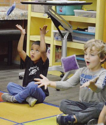Pre-K Students Ezekiel Garcia, left, and Cory Stoner use beanbags to learn about pitch during music class Thursday afternoon at Nance Elementary School. CDN | Micah Ashcraft
