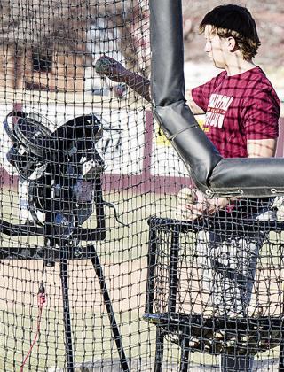 Vince Jones loads the pitching machine during a batting drill in practice. CDN | Sam Goodwyn