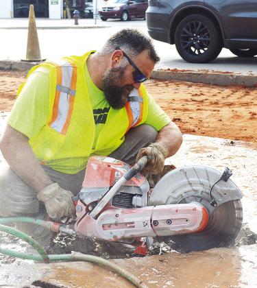 Blake Allen cuts out chucks of concrete from a sidewalk area Tuesday morning, just off of Gary Boulevard. CDN | Micah Ashcraft