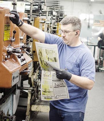 Eric Hunter reads over a copy of the newspaper as he works the press in the back of the Clinton Daily News. CDN | Sam Goodwyn