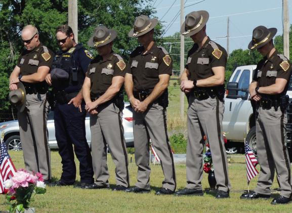 Oklahoma Highway Patrol troopers and a representative of the Clinton Police Department bow their heads for the moment of silence during the Memorial Day service Monday at Clinton Cemetery. From left are Trooper Barrett Karlin, CPD Sgt. Dillon Mach, Trooper Pate Gossen, Lt. Aaron Hunter, and Troopers Jared Bose and Jace Lovelady. CDN | Christian Jacobsen