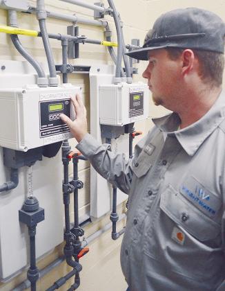 Aaron Ruben adjusts the level of chlorine gas with an automatic gas feeder in the new Chemical Feed Building at the Clinton Lake Water Treatment Plant. CDN | Micah Ashcraft