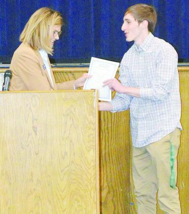 Dayna Hardaway, left, awards the Southwestern Oklahoma State University Academic Scholarship to Owen Lavigne during the Senior Awards ceremony at the A-B auditorium. CDN | Christian Jacobsen