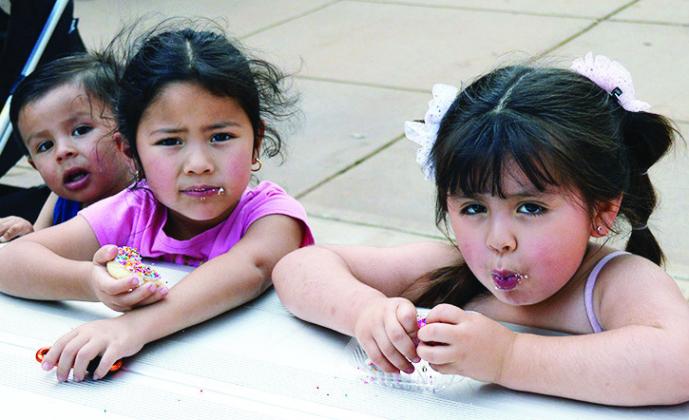From left, Orlando Jr. Andablo, Emily Navarrete, and Naomi Andablo enjoy a freshly made sugar cookie Thursday at the Farmer’s Market in Engleman Park.