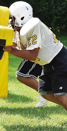 Clinton Middle School’s Edwin Mejia sticks his face into the blocking sled and pushes it during practice at the middle school. CDN |Sam Goodwyn