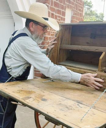Tom Ward of PropsWest examines the peddler’s cart, which is one of approximately 40 props the company is supplying for the production of “Oklahoma!” this fall. CDN | Shiann Dawson
