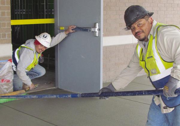 Adrian Carrillo, left, and Gabriel Martinez smooth out freshly poured concrete at the Troop H Oklahoma Highway Patrol Headquarters construction site. CDN | Christian Jacobsen