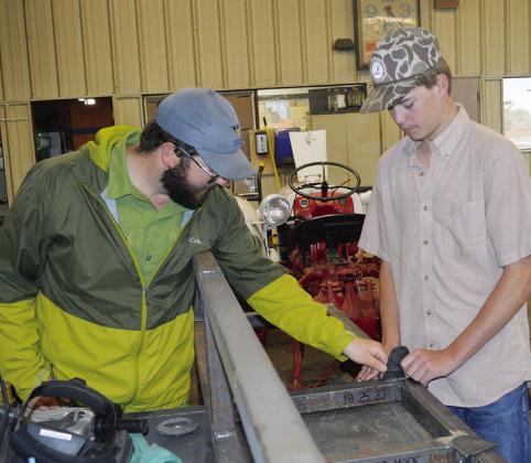 Ag teacher Mitchell Hunter checks the angle of John Vela’s cut at Arapaho-Butler High School. CDN | Christian Jacobsen