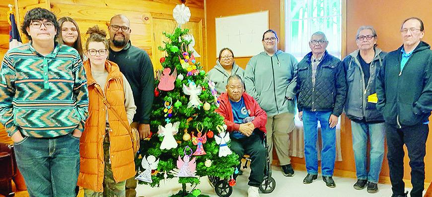From left, Jaxon Ruiz, Jalan Ruiz, Toni Ruiz, Justin Ruiz, Tammie Goodblanket, Jason Goodblanket, Kendrick Fletcher, Pastor Gerald Panana, Eugene Beachhead, and Chris Tallbull stand together as the Clinton Indian Baptist Church accepts a donation from Che