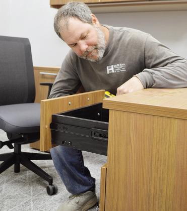 Dustin Sweatt finishes putting together an office desk into one of the rooms of the nearly completed site of the new Clinton Middle School building Thursday afternoon. CDN | Micah Ashcraft