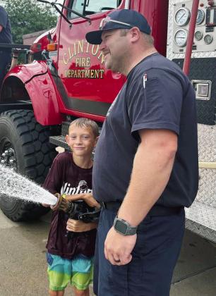 Wyatt Baily, left, is assisted by Clinton Fire Department’s Lt. Joe Williams as he tests out the fire hose at Washington Elementary. CDN | Courtesy photo