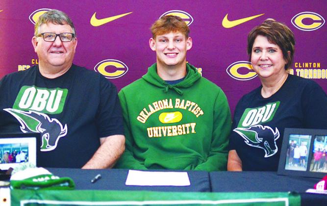 Clinton’s Wyatt Willoughby, center, celebrates Friday with his father Rodney, left, and mother April, right, after signing to throw for Oklahoma Baptist University’s track and field team next year. CDN | Sam Goodwyn