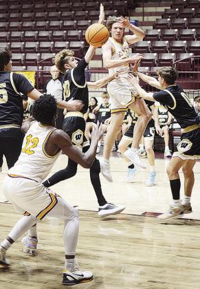 Clinton’s Ayden Crumley flies through the air as he passes the ball to No. 12 Atticus Thompson through a horde of defenders during the Reds’ home game Tuesday against Woodward. CDN | Sam Goodwyn