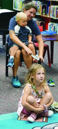 The Challis family visits for story time at the Clinton Public Library. Molly is helping Ollyn with his sock, as Winlynd listens intently on the story. CDN | Christian Jacobsen