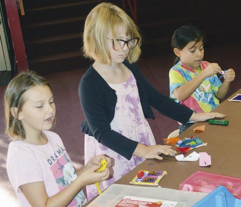 From left, Olivia Cantu, Clara Gregory, and Nayeli Santoyo are working on crafts during MakerSpace in the Southwest Elementary library. CDN | Christian Jacobsen