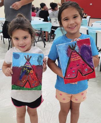 Mya Hines, left, and Paisley Hines show their teepee paintings during the Native Country Creative Arts paint party Sunday at the Cheyenne and Arapaho ERC Building on Dog Patch Road. CDN | Courtesy photo