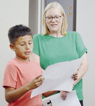 Fourth-grader Jarrod Moss, left, presents a book report to the Clinton Public Schools Board of Education, alongside Southwest Elementary School Librarian Christy Stephens. CDN | Micah Ashcraft