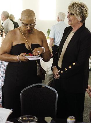 Carla Bell, left, and fellow member of the 2026 Clinton Hall of Fame Class Jamie Siess reconnect during the social prior to the ceremony Saturday in the Frisco Center. CDN | Sam Goodwyn