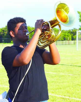 Kristian Bennett holds at attention during an after-school marching band rehearsal for the Pride of Clinton Monday evening. CDN | Micah Ashcraft