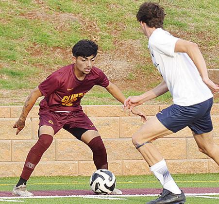 Clinton’s Austin Reynaga, left, schemes how to get the ball around the Heritage Hall defender during the Red Tornadoes’ home win Monday over the Chargers. CDN | Sam Goodwyn