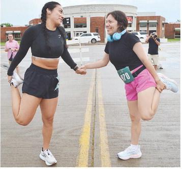 Caren Alvarez, left, and Jackie Shirkey stretch prior to taking part in the Clinton Classic Run Saturday. CDN | Micah Ashcraft