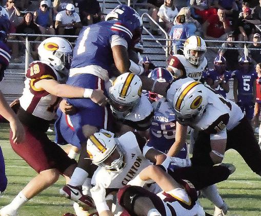 Clinton’s Dyson Moss, far left, and Gavin Evans, far right, leads a bevy of defenders as they stop the Chandler ball carrier during the Red Tornadoes’ road win Friday over the Lions to open the season. CDN | John Kinsey