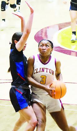 Clinton’s Arlena Kirkendoll fights through a Harrah defender during the Lady Reds’ season opener. CDN | Sam Goodwyn