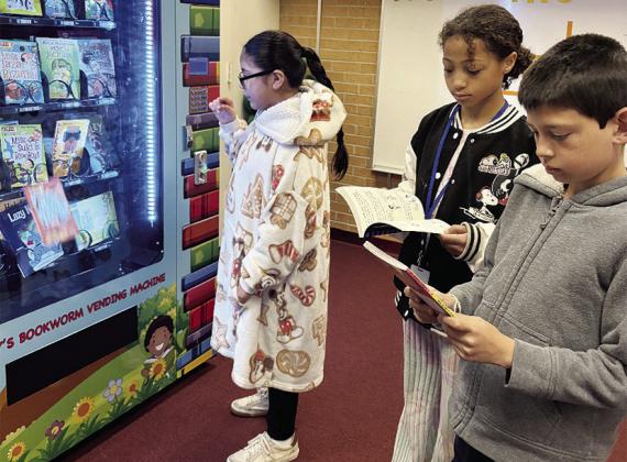 From left, Andrea Gamez, Reighlyn Stanton, and Maurico Nava check out the free books they received for winning raffles during the Read Across America campaign at Southwest Elementary School. They received tickets for completing reading assignments. Winner