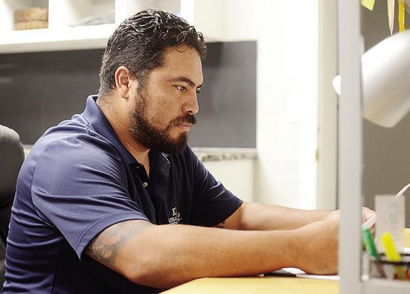 Mario Martinez looks over some paperwork before he starts his day at Kiesau-Lee Funeral Home. CDN | Sam Goodwyn