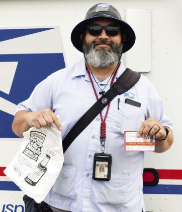 Mail Carrier Matthew Lantz drops off plastic bags to residents during his morning route for the Stamp Out Hunger Food Drive in Clinton. CDN | Christian Jacobsen