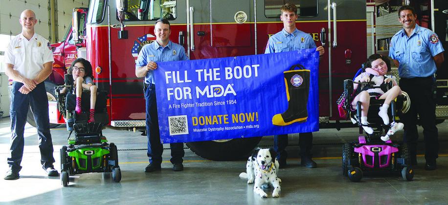 From left, Capt. Tyler Calvert, Josh Sorter, Jacob Hoffman, Tilly the Fire Dog, Lt. Bobby Winans, Emory Sorter, and Alex Tyler pose for a picture Friday at the Clinton Fire Department. They are getting ready for the annual Fill the Boot for MDA event to be held 7 a.m. to 5 p.m. Friday at the intersection of W. Gary Boulevard and S. 4th Street. CDN | Christian Jacobsen