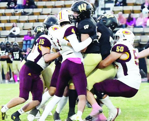 Clinton’s No. 15 Dyson Moss, No. 4 Zaryk Baker and No. 50 Alex Amaya take down the Woodward ball carrier during the Red Tornadoes’ win over the Boomers. CDN | John Kinsey