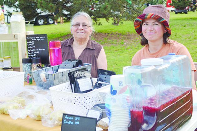 Cindy Frisby, left, and Karen Hoover sit at their pop-up stand where they sold handmade goods during the first Levitt concert. CDN | Micah Ashcraft