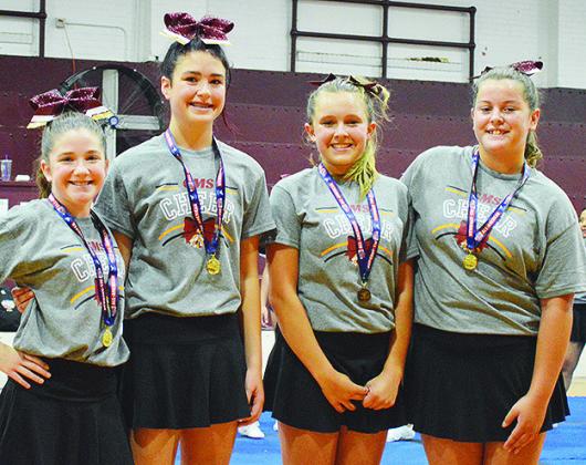 Clinton Middle School cheerleaders, from left, Maysen Mosburg, Chanel East, Harmonee Cates, and Lily Starnes accept their medals for being selected All-American after their summer cheer camp last Thursday at the CMS Auditorium. CDN | Micah Ashcraft