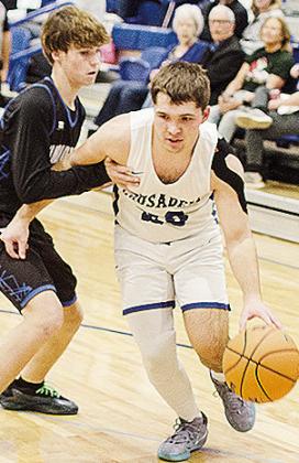 No. 20 Zach Zybach, right, fights through an O-E defender as he heads toward the basket during the Crusaders’ home win over the Diamondbacks. CDN | Sam Goodwyn
