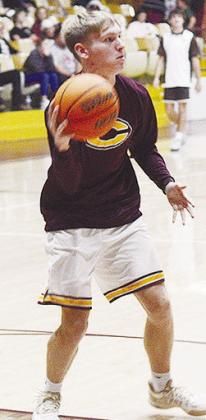Clinton’s Parker Adams passes the ball during a warm-up drill prior to the Reds’ home district game against Elk City. CDN | Sam Goodwyn
