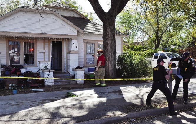 After Wednesday’s house fire, Clinton Fire Department Capt. Justin Hill takes photos of the damage at 614 Hayes Ave., while Clinton Police Officers Wylie McIntyre and Braeden Blanchard place police tape around the scene. CDN | Staff Photo