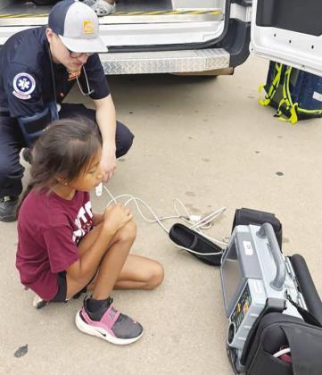 Adelyn Lonebear is instructed by AEMT Grant Spillman how to use his medical equipment at Washington Elementary. CDN | Courtesy photo