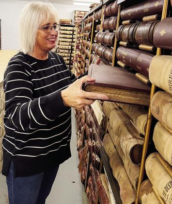 Custer County Clerk Melissa Graham pulls from the records in the Custer County Archives, housed in the former county jail after recent renovation, at the Custer County Courthouse. CDN | Shiann Dawson