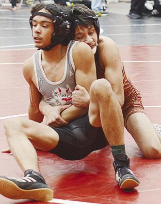 Brandon Rodriguez-Esclalante, behind, wraps himself around his opponent during the first day of the Class 4A Wrestling Tournament in Weatherford. CDN | Sam Goodwyn
