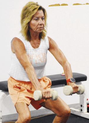 Tammy Shepherd shows control during her extended dumbbell raises at Acme Brick Park. CDN | Christian Jacobsen