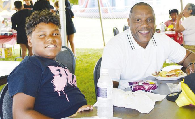 Tru Randle, left, and Jerome Hurd enjoy the food at the recent Juneteenth celebration at Bethany Baptist Church. CDN | Christian Jacobsen