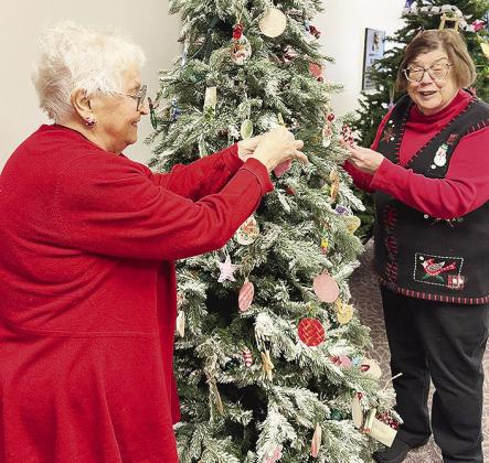 Lois Schimmels, left, and Glenda Kindsfather decorate a tree in the lobby of the hospital with decorations made by students of Clinton Public Schools. CDN | Shiann Dawson