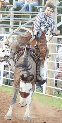 Tyler Smith holds on for dear life as his horse gets close to the railing in the saddle bronc riding event as a part of the rodeo Saturday. CDN | Sam Goodwyn