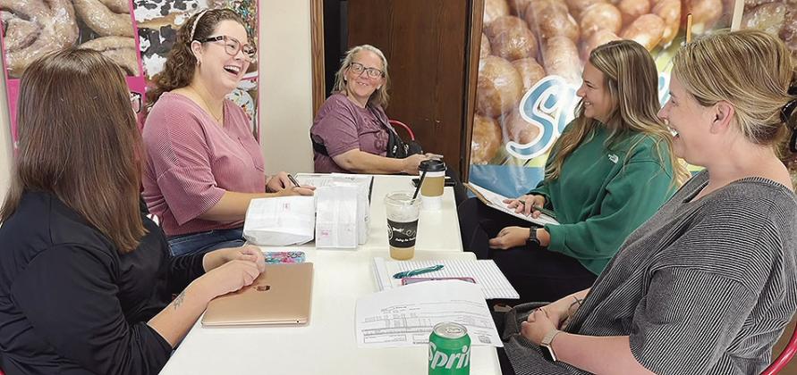 From left, Brittany Miller, Stacie Nickel, J.J. Thompson, Chelle Gutermuth, and Erin Giles share breakfast and a laugh during a meeting of Junior Service League’s officers to prepare for the upcoming Spaghetti Day fundraiser. CDN | Shiann Dawson