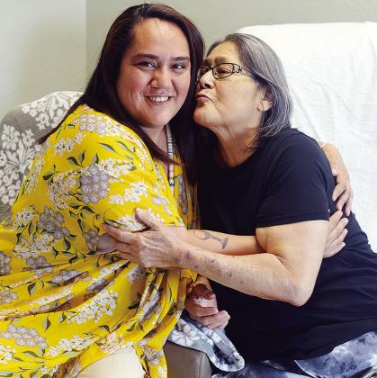 Lorena Dominguez, left, hugs her mom, Trina Verjan, who is about to surprise her with a smooch, at River Valley Skilled Nursing and Therapy. CDN | Michael Maresh