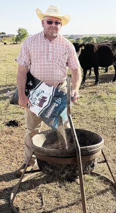 Rick Weedon smiles as he recently fills the cattle feeder for his hungry customers. CDN | Courtesy photo