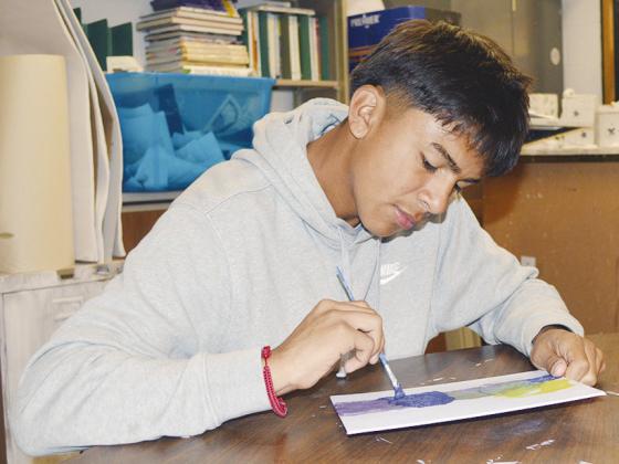 Fabian Martinez adds additional colors to his abstract art piece at Clinton High School. CDN | Christian Jacobsen
