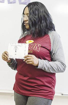 Tosha Jones instructs her students on what to do with the Martin Luther King Jr. coloring book as they celebrate Black History Month at Eastside Academy. CDN | Sam Goodwyn